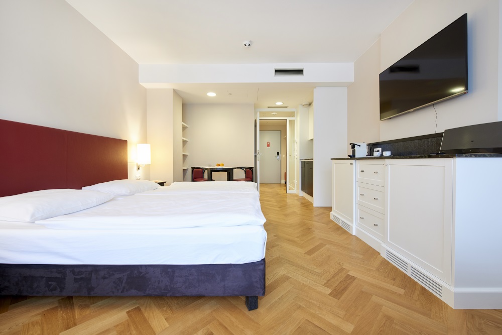 Deluxe Studio Apartment - Doppelzimmer mit Fernseher, Esstisch und kleiner Küche